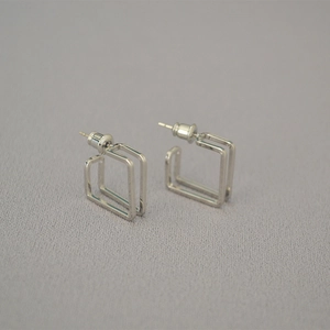 Detailed view of silver square geometric stud earrings with double-line hollow design