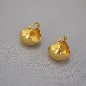 Detailed 45-degree angle of vintage chunky hollow sphere gold-plated brass hoop earrings