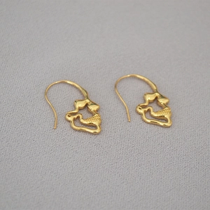 Close-up of gold-plated brass skull earrings with artistic abstract design for women