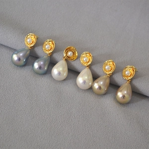 Detailed view of colorful drop pearls with vintage gold bases and 925 silver needles