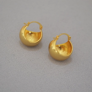 Detailed top view of vintage minimalist hollow gold-plated sphere hoop earrings on grey surface