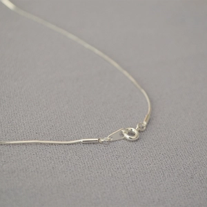 Dettaglio di una collana a catena serpente argento con chiusura a molla rotonda e maglia
