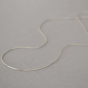 Macro di una sottile catena a serpente d'argento con una superficie lucida minimalista