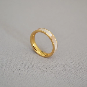 Vue macro d'une bague minimaliste en laiton doré avec incrustation de nacre blanche