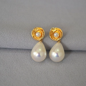 Detail of French vintage gold flower earrings with iridescent teardrop pearls