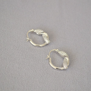 Orecchini a cerchio annodati in argento con cristalli pavé e design minimalista chic