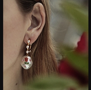 Baroque pearl earrings with rose print and crystals shown on model in outdoor natural light