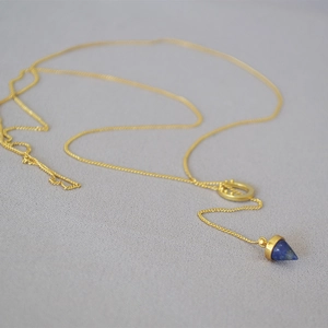 Minimalist brass gold chain necklace featuring a blue lapis lazuli cone pendant and ring