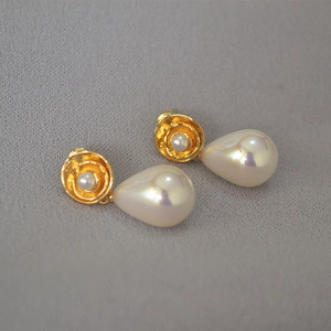Detail of vintage gold flower earrings with iridescent pear-shaped teardrop pearls