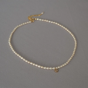 Elegant freshwater pearl necklace with a blue evil eye pendant and gold-plated hardware
