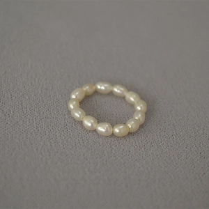 Macro detail of natural freshwater rice pearl elastic ring with creamy white luster