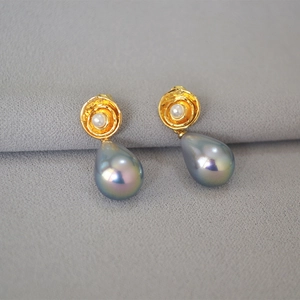 Detail of vintage gold flower stud with colorful luster teardrop pearl earrings