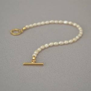 Detailed macro view of an elegant freshwater pearl bracelet with a golden OT toggle clasp