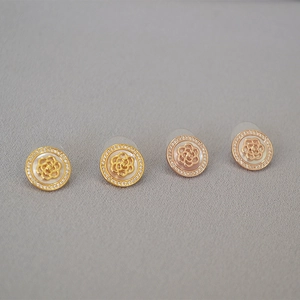 Détail de boucles d'oreilles camélia avec nacre et micro-sertissage de zircons cubiques