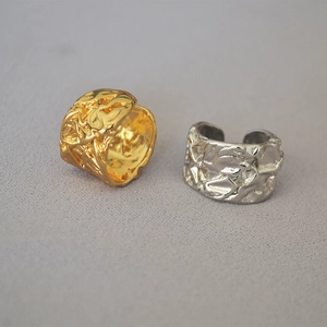 Detail showing irregular molten texture on gold and silver wide open brass rings