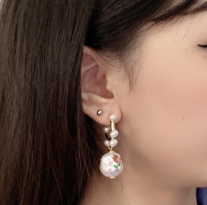 Close-up of French vintage baroque pearl earrings with rose print on model