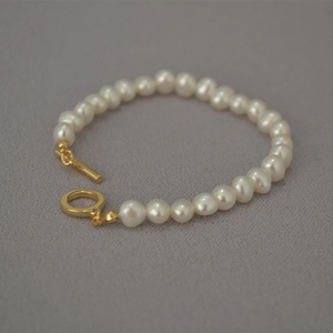 Elegant French style irregular freshwater pearl bracelet with gold OT clasp on grey base