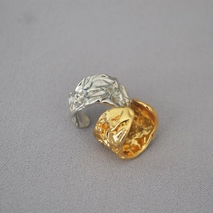 Macro shot of gold and silver hammered lava rings with liquid metal texture design