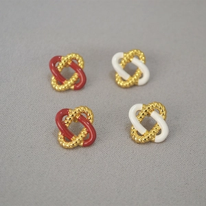 Macro shot of 925 silver stud earrings with red enamel twisted knot design detail
