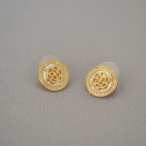 Vue macro détaillée des boucles d'oreilles camélia plaqué or avec zircons brillants
