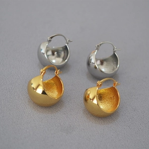 Detailed macro view of gold and silver chunky hoop earrings with polished finish