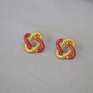 Close-up of red enamel and gold-plated twisted rope knot earrings with 925 silver studs