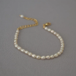 Detail of irregular freshwater rice pearls with golden lobster clasp and extender chain