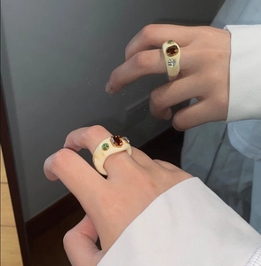 Detailed mirror selfie showing a chunky cream resin ring with amber rectangular gemstone