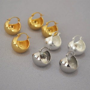Detailed macro view of gold and silver brass hoop earrings with mirror and matte finish