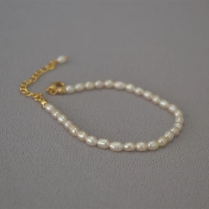 Detail of irregular freshwater seed pearl bracelet with gold lobster clasp and extension