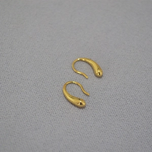Minimalistische goldene Tropfenohrringe mit Hochglanzfinish auf Texturhintergrund
