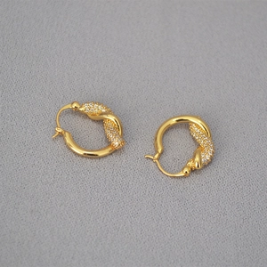 Dettaglio degli orecchini a nodo dorati con pavé di cristalli di zirconia cubica