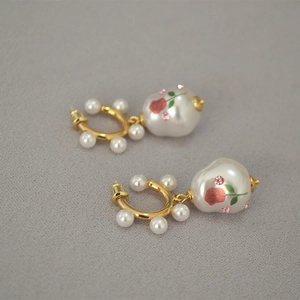 Detail of baroque pearl drop earrings featuring vintage red rose pattern and pink crystals