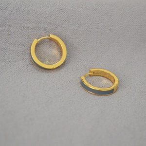 Détail de boucles d'oreilles en laiton doré avec émail gris et fermoir à charnière sûr