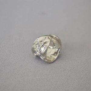 Modern irregular hammered silver ring with lava texture and tiny zircon stones