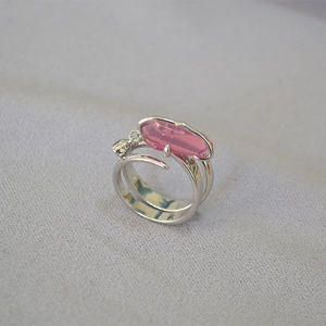 Dettaglio anello argento con cristallo rosa e piccolo ciondolo a forma di teschio