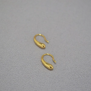 Nahaufnahme minimalistischer goldener Tropfen-Ohrhaken mit poliertem Finish