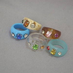 Detailed view of colorful resin rings set with vintage rhinestones and emerald cut gems