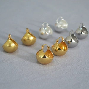 Modern gold and silver hoop earrings in polished and matte finish on textured background