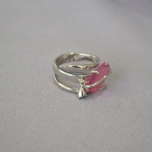 Anello d'argento con cristallo rosa e ciondolo a cuore su tessuto blu testurizzato