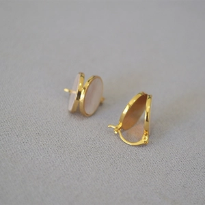 Boucles d'oreilles minimalistes en laiton doré avec nacre colorée sur tissu gris