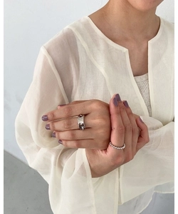 Close-up of a silver irregular chain ring set on a hand with hammered texture and beads