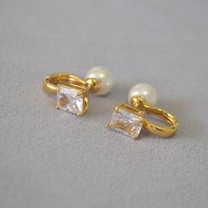 Dettaglio orecchini placcati oro con zircone rettangolare e perla per donna
