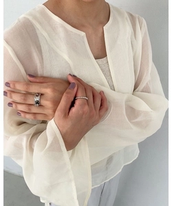 Close-up of irregular silver chain link rings and bead texture band on model's hand