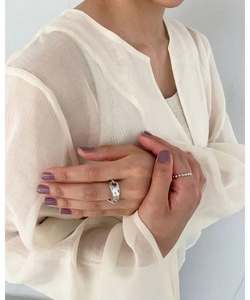 Detail view of silver irregular chain link ring and minimalist beaded ring on finger
