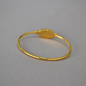 Bracelet jonc minimaliste plaqué or avec incrustation d'opale, vue sous un angle de 45°