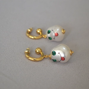 Baroque pearl earrings with rose print and playful face detail on gold hoop