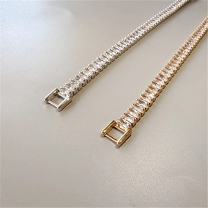 Détail macro de bracelets en zircone rectangulaire, coloris or et argent, avec fermoirs