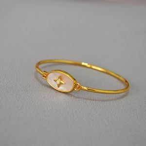 Vue détaillée du bracelet en laiton doré avec nacre blanche et incrustation d'étoile