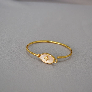Détail macro du bracelet en laiton doré avec incrustation de nacre et motif étoile